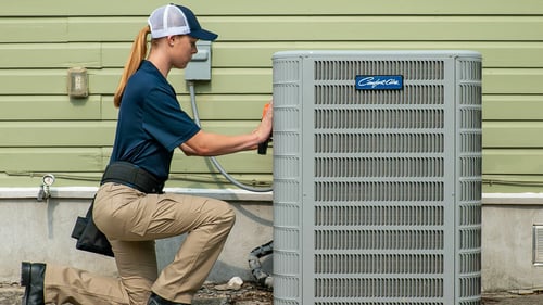 A Radiant HVAC technician working on a Carrier AC Unit