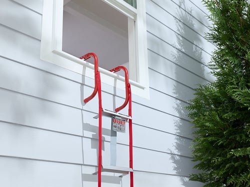 A Kidde Fire Escape Ladder is hanging from a second floor window.