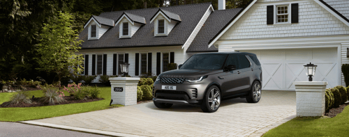 Eiger Grey Discovery parked on a driveway outside a white suburban house