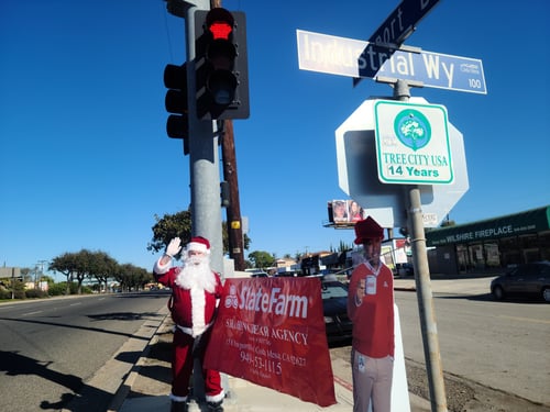 Santa standing at street corner with State Farm sign and Jake from State Farm