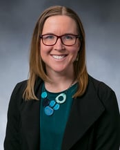 Dr. Hester smiling in front of a gray background.