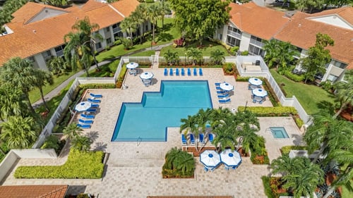 Expansive resort style pool with sundeck and lounge chairs.