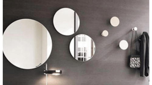 3 circle mirrors of different shapes hanging up on a wall