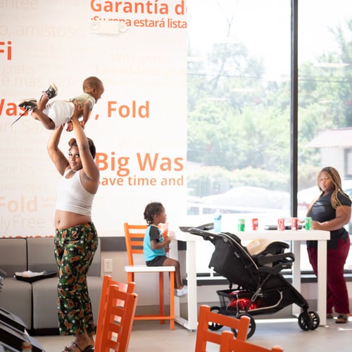 Customer and child inside a clean Speed Queen Laundry laundromat