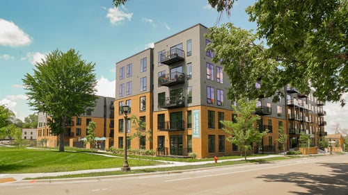 Modern four-story apartment building with balconies and brick facade at The Hill Apartments in St Paul, Minnesota