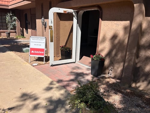 Brown building with red State Farm sign out front of front door