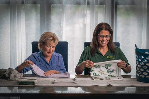 Home Instead Caregiver assisting client in light house keeping