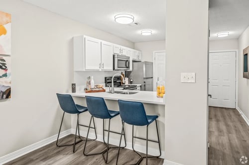 Kitchen with eat in island and three blue bar stools at Coastline Apartments in Fort Walton Beach, FL, 32547