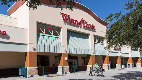 Man and child walking out of Winn Dixie with Shopping cart