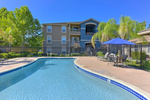 Swimming pool with patio furniture and iron safety fence at Whitney Ranch Apartments, Rocklin, 95765