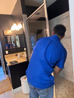 bluefrog plumber inspecting low water pressure in a bathroom shower