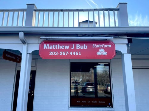 White brick building with red and white State Farm sign