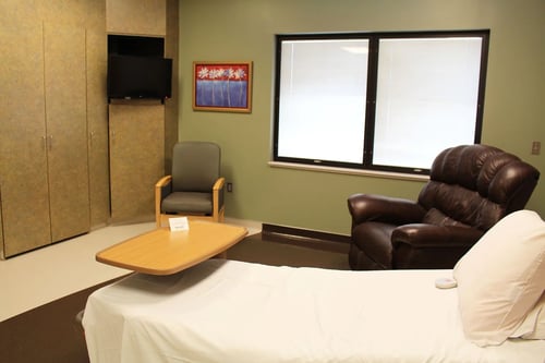 A different view of a labor and dlivery room showing recliner and TV.