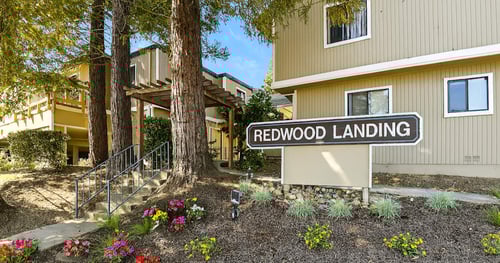 A sign that says Redwood Landing in front of a building