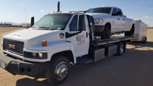 white tow truck with pickup on bed