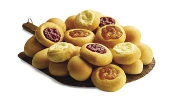 An assortment of fruit, cream cheese, ham and cheese, bacon and cheese, smoked sausage, and sausage and cheese kolaches