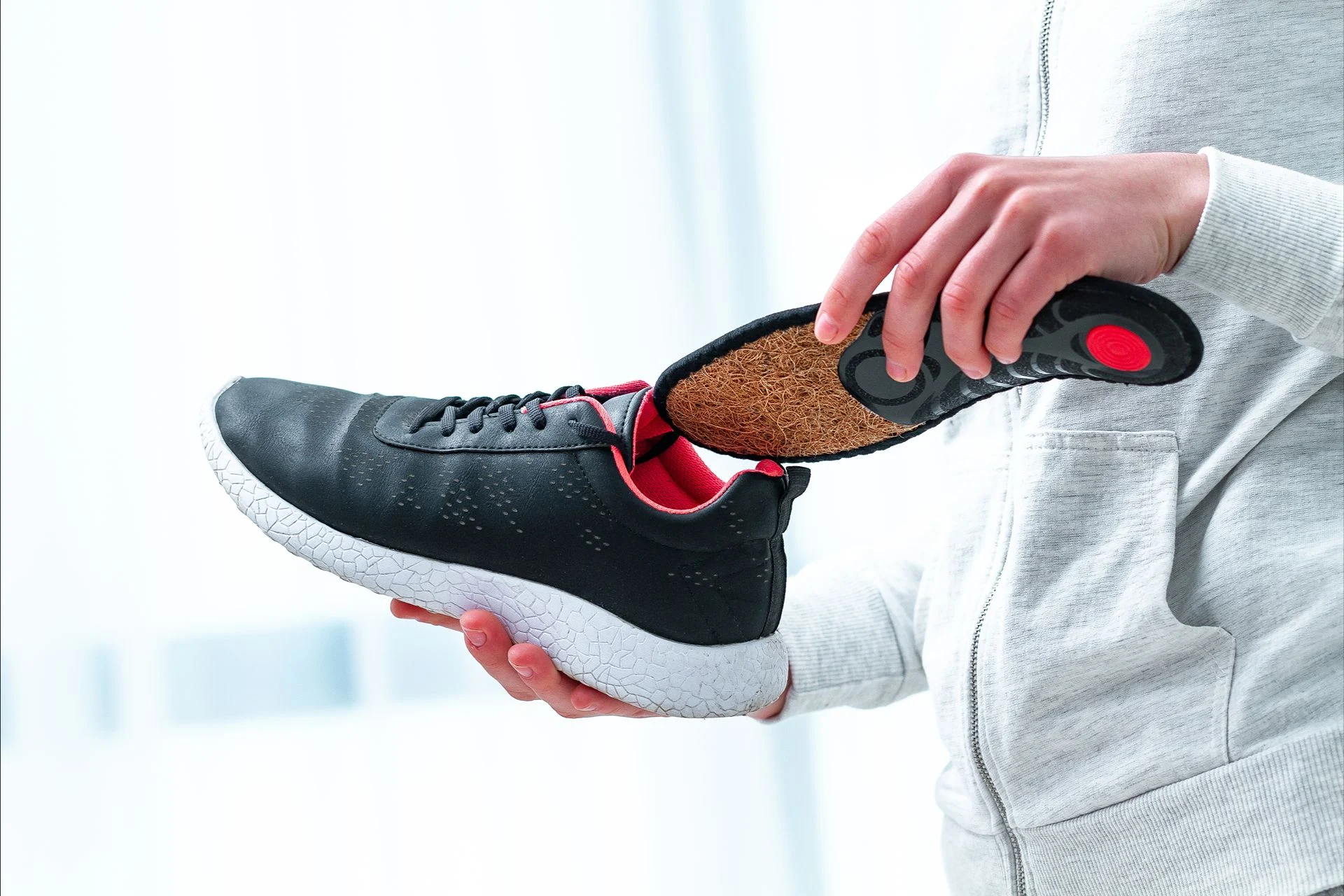 person inserting custom orthotics into their shoe