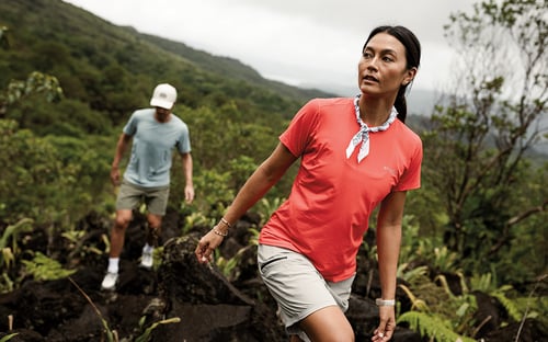 Woman and man hiking in lush mountain