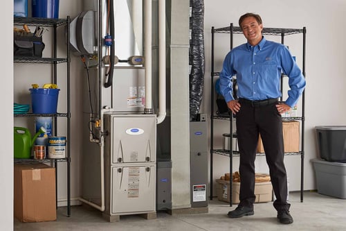 A Carrier dealer completes a furnace installation in a basement