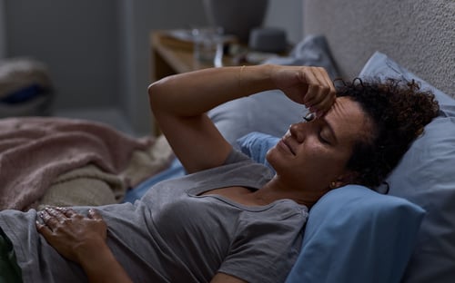 woman sleeping with a headache