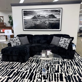 Discover the Midnight Madness Sectional at Slumberland Furniture Burlington in Burlington, Iowa. Featuring plush black upholstery, generous seating and a chaise for stretching out, Midnight Madness combines contemporary style with everyday comfort. Its dramatic look makes it an eye-catching centerpiece for modern living rooms, family rooms and entertainment spaces. Visit our locally owned Burlington furniture showroom to experience the Midnight Madness Sectional in person and explore sectionals, sofas, accent tables, area rugs, wall art and home décor to create a complete living room.