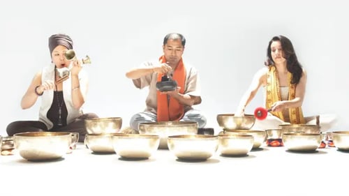 Three people sitting next to each other doing sound healing