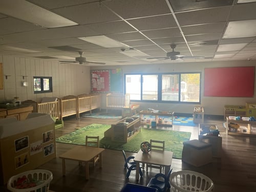 Bright, colorful Pre-K classroom filled with learning materials, art supplies, and play areas for growing minds.