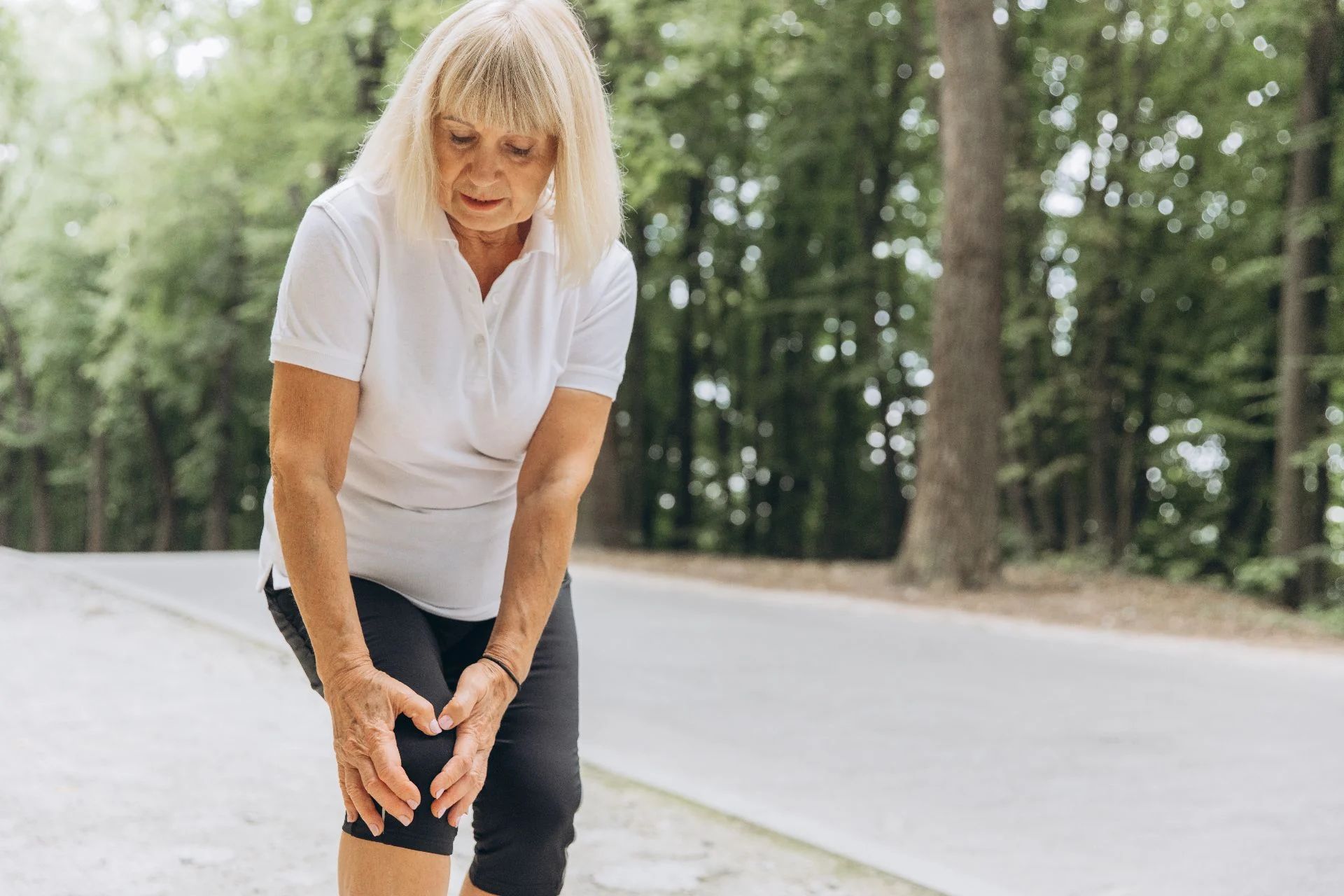 Elderly person holding their knee in pain