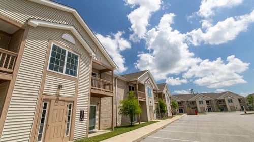 McCormick Manor exterior view of modern two-story apartment buildings with beige siding and balconies.