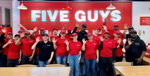 Crew members pose for a photograph inside the dining room ahead of the grand opening of the Five Guys restaurant at 601 Harry L Drive in Johnson City, New York.