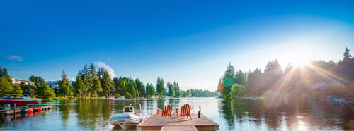 Cottage, muskoka chairs over a lake