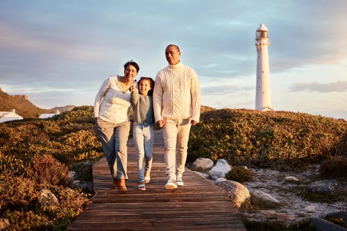Grands-parents avec leur petite-fille sur la promenade devant le phare