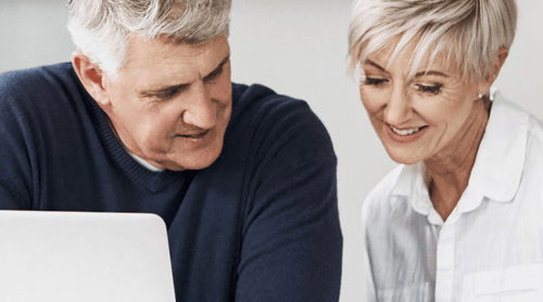Older couple sitting next to each other reviewing documents