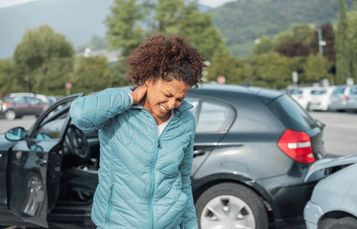 Car accident victim holding the back of their neck after a car accident