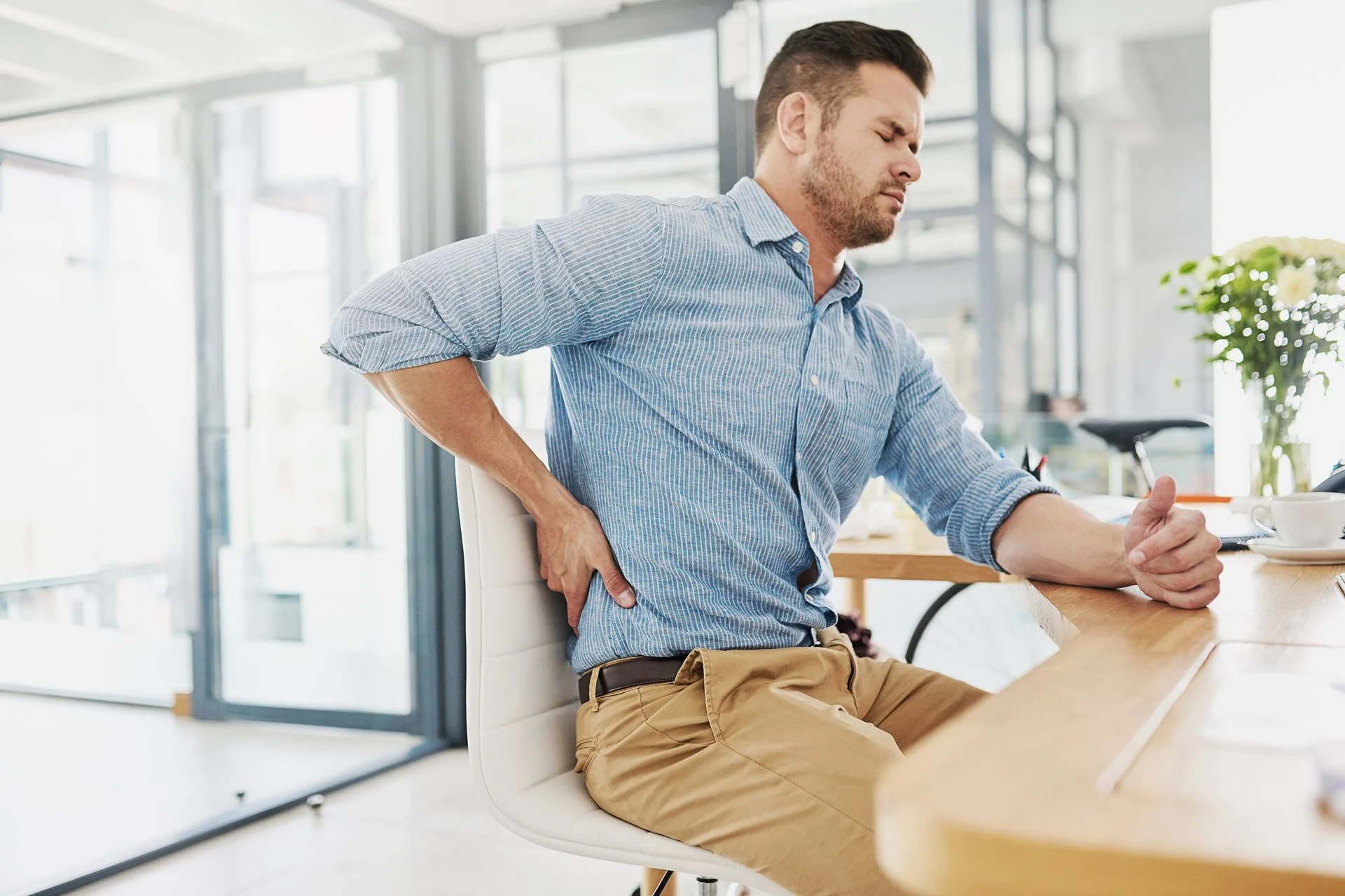 man sitting at desk experiencing lower back pain