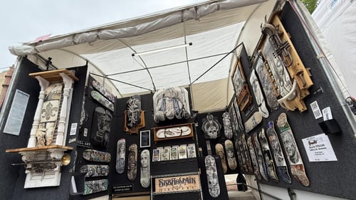 Tent at event full of custom skateboard art