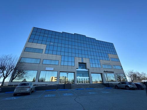 A wide shot photo of the side of a multi-level office building in Anchorage, AK. The First American Title logo is on the right side of the second floor.