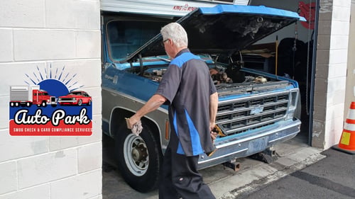 Auto Park Smog Service employee working on blue truck