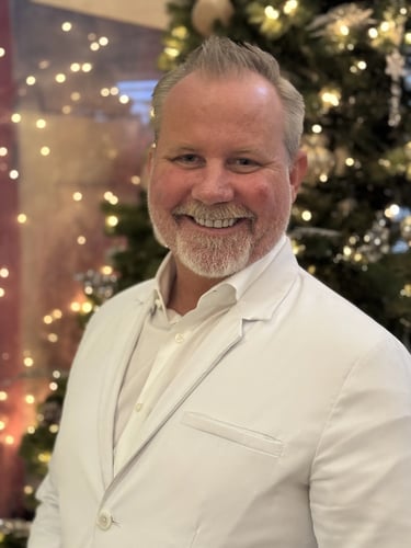 Dr. Hahn smiling warmly in front of a lit christmas tree