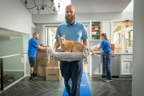 Moving crew holding customers pet