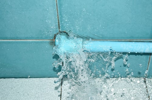 Water gushes out of a loose fitting on a water pipe, resulting in water damage to nearby areas.