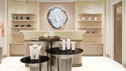 Luxurious spa with modern decor, a central display of skincare products and jewelry, soft lighting and a large agate wall accent