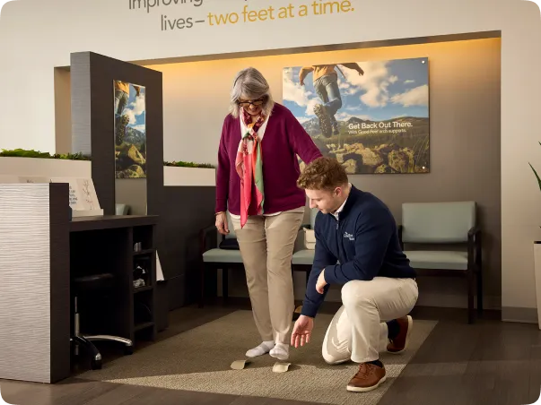 Empleado ayudando a una anciana con la prueba de equilibrio