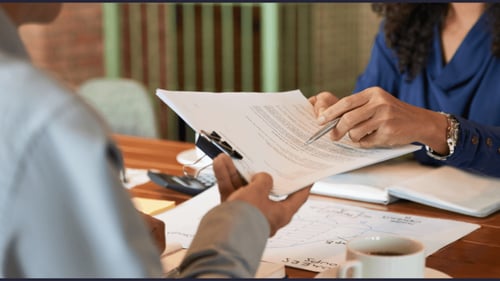 Two people going over documents at table