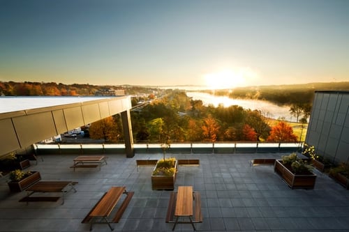 Rooftop terrace with picnic tables, with views of Lac des Nations and autumn trees, seen from above