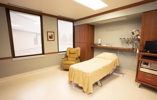 Another view of a labor and delivery room showing a bed, recliner and monitoring equipment