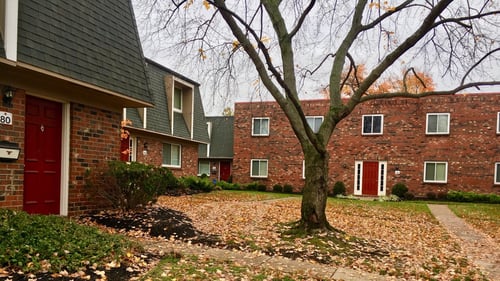 Brick apartment buildings with fallen leaves on the ground