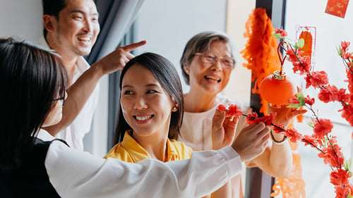 Multi-generational family gathered in front of brightly colored blossoms