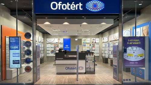 Ofotért üzlet bejárata Budapesten, az Etele Plázában, üvegportálos homlokzattal és kivilágított belső térrel.