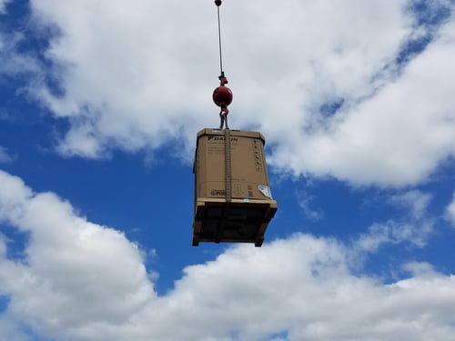 bringing in an AC unit with a crane